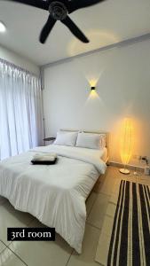 1 dormitorio con 1 cama blanca grande y ventilador de techo en The Borneo Suite - For group of 6 en Kota Kinabalu