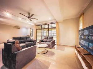 a living room with two couches and a flat screen tv at JB GatheringHouse Bungalow 5Bedroom 12pax in Johor Bahru