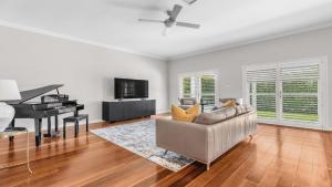 een woonkamer met een bank en een piano bij Vintage Lodge in Pokolbin