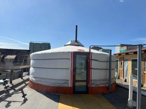 ウランバートルにあるガナズ ゲストハウス & ツアーの屋根の上に座る白赤のトレーラー