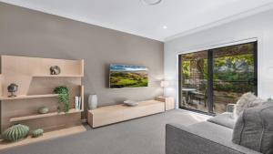 波高尔宾Amaroo Lodge - The Vintage的带沙发和大窗户的客厅