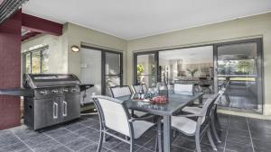 a dining room with a table and chairs and a grill at Amaroo Lodge - The Vintage in Pokolbin