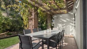 a black dining table and chairs on a patio at Amaroo Lodge - The Vintage in Pokolbin