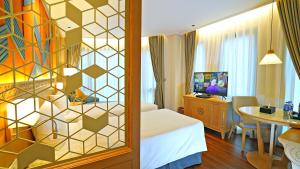 una camera d'albergo con letto, scrivania e tavolo di SAIGON_AROMA_HOTEL a Hanoi
