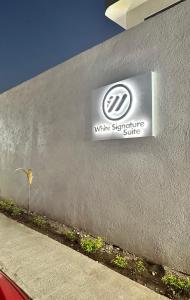 a white signature sign on the side of a building at White Signature Suite in Kingston