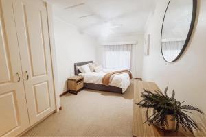 伦马克Paringa Riverside Resort的带床和大镜子的卧室