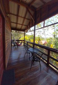 - une terrasse couverte avec un hamac, une table et des chaises dans l'établissement Santa Cruz Cabins, à Santa Elena