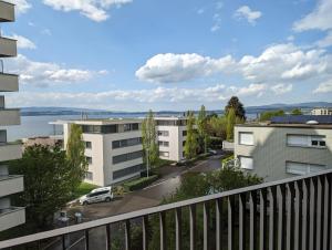 Cet appartement dispose d'un balcon offrant une vue sur une rue et les bâtiments. dans l'établissement 4,5 room apartment with lake view, à Zoug