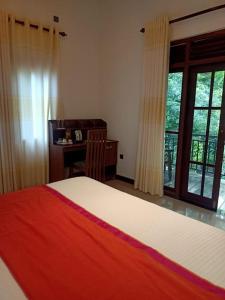 um quarto com uma cama, uma secretária e uma janela em Villa Serena Galle em Galle