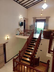 Habitación con escalera de madera y TV. en Villa Serena Galle en Galle