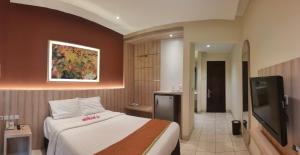 a bedroom with a bed and a flat screen tv at D'Bamboo Suites in Jakarta