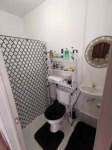 een badkamer met een toilet, een wastafel en een spiegel bij Vacation House Tagaytay-Nasugbu in Nasugbu