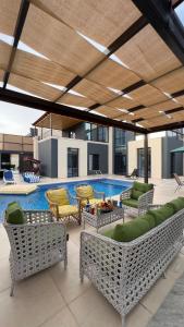 eine Terrasse mit Stühlen und einem Pool in der Unterkunft Dahab villa in Al Rama