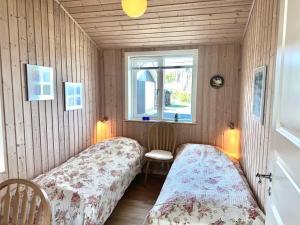 Habitación pequeña con 2 camas y ventana en Holiday Home With Exceptional Sea View, en Børkop