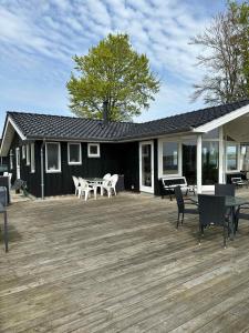 una terraza con sillas, una mesa y una casa en Holiday Home With Exceptional Sea View, en Børkop