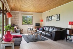 - un salon avec un canapé en cuir et une table dans l'établissement Summer Cottage Idyll At Natures Pearl,, à Stubbekøbing