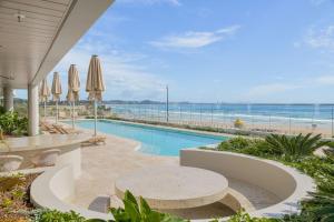 - une piscine avec une table et une vue sur la plage dans l'établissement Miles on Kirra Unit 907, à Gold Coast