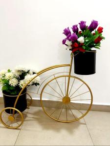 uma bicicleta dourada com flores ao lado de uma parede em Luxurious One Bed Apartment Gold Crest Mall em Lahore