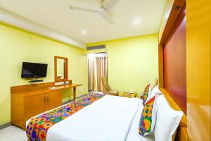 a bedroom with a bed and a television in it at FabHotel Prime Mahalaya Residency in Chennai