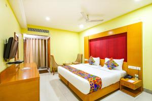 a hotel room with a large bed and a television at FabHotel Prime Mahalaya Residency in Chennai