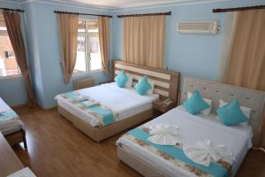 2 camas en una habitación con paredes azules en The Time Hotel Adana, en Seyhan