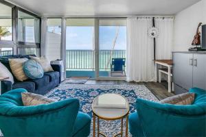 ein Wohnzimmer mit blauen Möbeln und Meerblick in der Unterkunft Luxury Beachfront with Breathtaking views & AC in Hauula