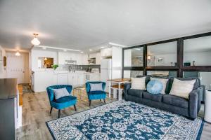 ein Wohnzimmer mit einem Sofa und Stühlen sowie eine Küche in der Unterkunft Luxury Beachfront with Breathtaking views & AC in Hauula