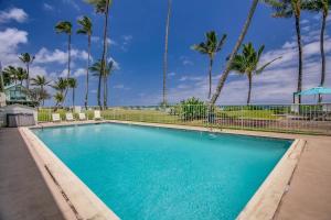 una piscina con palmeras en el fondo en Luxury Beachfront with Breathtaking views & AC, en Hauula