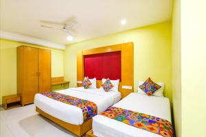 a hotel room with two beds with colorful pillows at Fabhotel Prime Mahalaya Residency - Nr Pallavaram Railway Station in Chennai