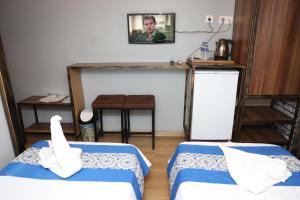 una habitación con 2 camas y una foto de un hombre en The Time Hotel Adana en Seyhan