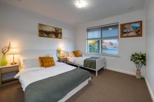sypialnia z 2 łóżkami i oknem w obiekcie 2B cozy house near the airport w mieście Perth