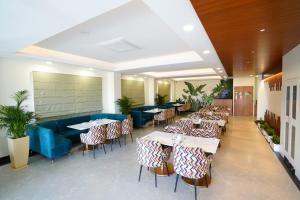 齋浦爾的住宿－Cilantro Comfort Jaipur，一间带桌椅和蓝色沙发的餐厅