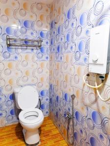 a bathroom with a toilet and a blue and white wall at ARK HOTEL SUBANG in Shah Alam