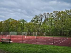 kort tenisowy z ławką na górze w obiekcie Belle maison dans domaine d'exception w mieście Saint Gatien des Bois
