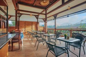 a restaurant with tables and chairs on a balcony at Navalia Villa Bedugul in Bedugul