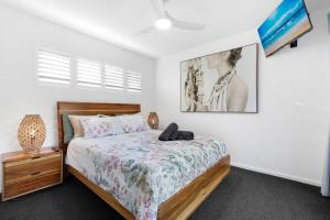 a bedroom with a bed and a picture on the wall at Elvis on Brodie - luxury boutique accommodation in Coffs Harbour