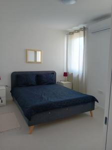 1 dormitorio con 1 cama azul en una habitación blanca en Kalista, en Osijek