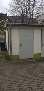 a garage with two white doors on a building at Pension Rudolph Riesa in Riesa