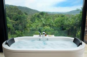 a bath tub with a view of a forest at Crystal Creek Rainforest Retreat in Crystal Creek