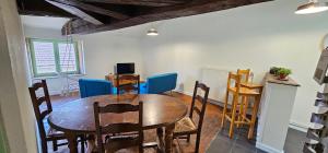 a dining room with a wooden table and chairs at Le Petit Grenette in Charlieu