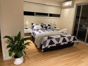 sypialnia z łóżkiem i doniczką w obiekcie Beauty of Healesville w mieście Healesville