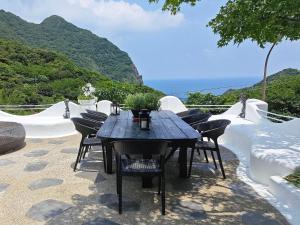 a black table and chairs on a patio with the ocean at 金石新月光 in Jiufen
