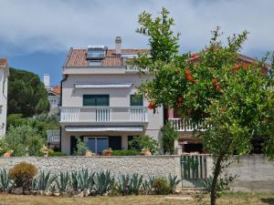 a white house with a fence and a tree at Cro Behar 2 Apartments in Sveti Petar