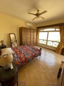a bedroom with a bed and a ceiling fan at فيلا دوبلكس مع حديقة وشواية in El-Tor