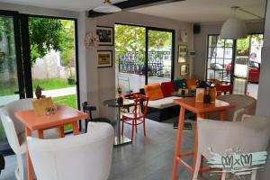 a living room with tables and chairs and a couch at Hotel Antigone in Tirana