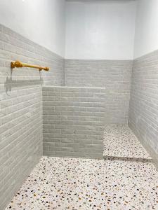 a bathroom with a shower with a tile floor at COCONUT BEACH BUNGALOWs & WARUNG in Amed