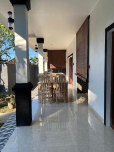 a patio with chairs and a table in a house at COCONUT BEACH BUNGALOWs & WARUNG in Amed