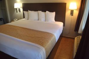 a bedroom with a large bed with white sheets and pillows at SF Central Hotel in San Francisco