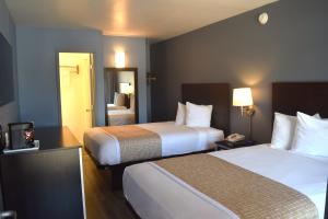 a hotel room with two beds and a mirror at SF Central Hotel in San Francisco