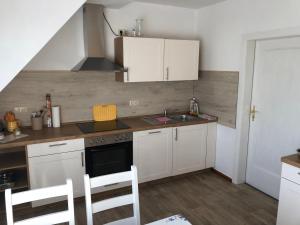 a small kitchen with white cabinets and a sink at Talblick 